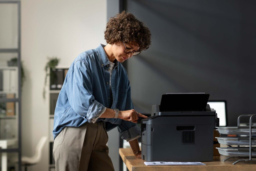 side view woman using printer